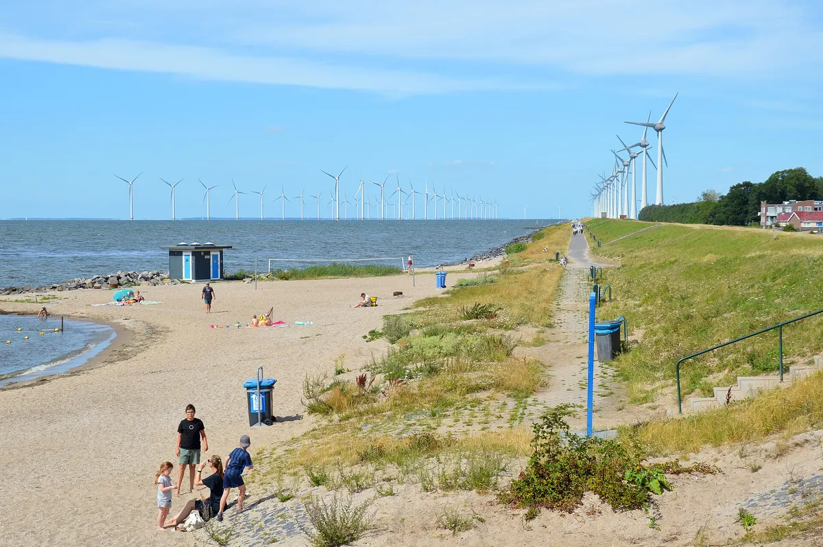 Пляж и ветряные электростанции в море